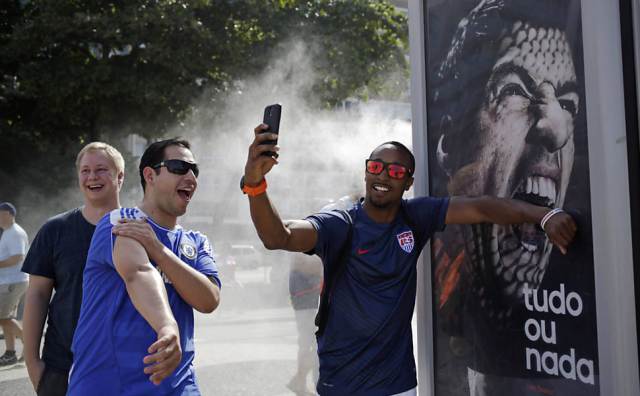 411042-970x600-1Torcedor dos EUA faz selfie como se estivesse sendo mordido pelo atacante uruguaio Luis Suárez, cuja foto estampa um anúncio em Copacabana, Zona Sul do Rio de Janeiro.