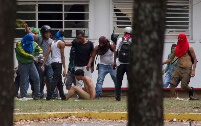 best-of-2014-from4Nu, aluno opositor ao governo venezuelano é espancado por jovens governistas em Caracas, na Venezuela, durante manifestação contra o desemprego crescente no país.